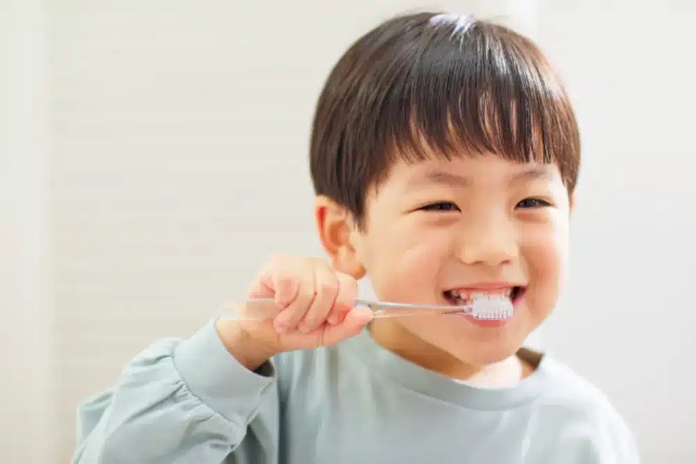 Smiling child brushing teeth at home, practicing everyday habits for a healthier smile with guidance from Rob Madry DDS in Corpus Christi.